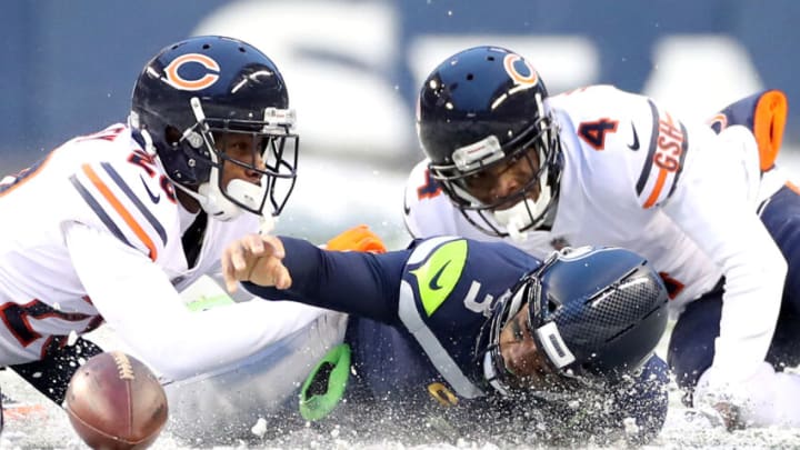 SEATTLE, WASHINGTON - DECEMBER 26: Russell Wilson #3 of the Seattle Seahawks loses the ball as he stretches to gain more yards, but Seattle is able to recover the ball during the second half against the Chicago Bears at Lumen Field on December 26, 2021 in Seattle, Washington. (Photo by Steph Chambers/Getty Images)