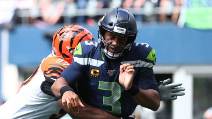 SEATTLE, WASHINGTON – SEPTEMBER 08: Russell Wilson #3 of the Seattle Seahawks is hit by Geno Atkins #97 of the Cincinnati Bengals in the first quarter during their game at CenturyLink Field on September 08, 2019 in Seattle, Washington. (Photo by Abbie Parr/Getty Images)