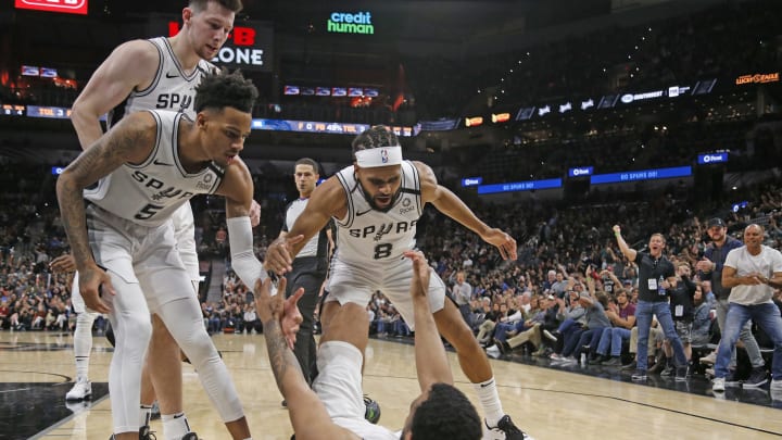 SAN ANTONIO, TX – FEBRUARY 29: Patty Mills #8 of the San Antonio Spurs and Dejounte Murray #5 help Trey Lyles #41 up after a one and during second half action (Photo by Ronald Cortes/Getty Images)