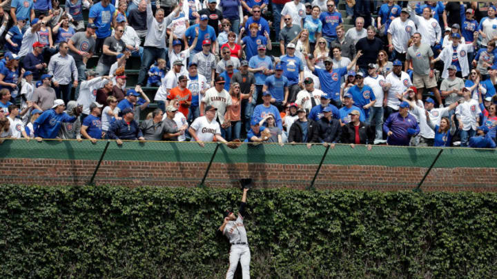 CHICAGO, IL - MAY 25: Mac Williamson #51 of the San Francisco Giants leaps in to the ivy to in an attempt to make a catch as fans reach for the home run ball of Kris Bryant #17 of the Chicago Cubs (not pictured) during the first inning at Wrigley Field on May 25, 2017 in Chicago, Illinois. (Photo by Jon Durr/Getty Images)