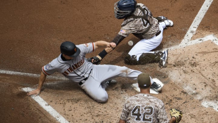 SAN DIEGO, CA - APRIL 15: Nick Hundley #5 of the San Francisco Giants, (L) scores ahead of the tag of Austin Hedges #18 of the San Diego Padres, (R) as Joey Lucchesi looks on during the second inning of a baseball game at PETCO Park on April 15, 2018 in San Diego, California. All players are wearing #42 in honor of Jackie Robinson Day. (Photo by Denis Poroy/Getty Images)