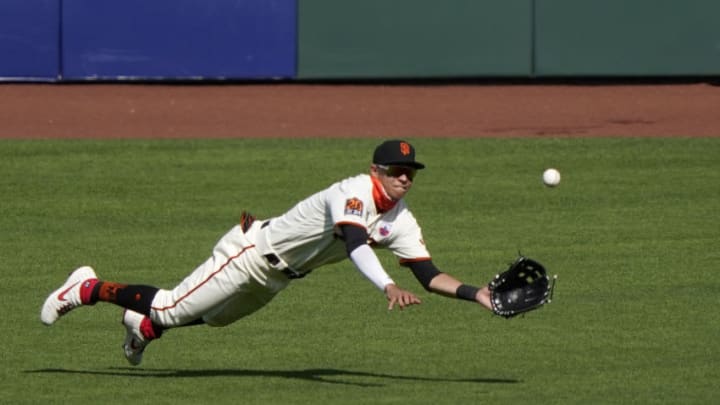 Mauricio Dubón #1 of the SF Giants makes a diving catch taking a hit away from Vimael Machin #39 of the Oakland Athletics in the top of the ninth inning at Oracle Park on August 16, 2020 in San Francisco, California. The Athletics won the game 15-3. (Photo by Thearon W. Henderson/Getty Images)