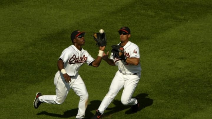 BALTIMORE - SEPTEMBER 10: Centerfielder Tim Raines Jr. #38 of the Baltimore Orioles steps in front of teammate Larry Bigbie #3 to catch a fly ball hit by Johnny Damon of the Boston Red Sox to end the fourth inning as the Red Sox defeated the Orioles September 10, 2003 at Oriole Park at Camden Yards in Baltimore, Maryland. (Photo by Doug Pensinger/Getty Images)