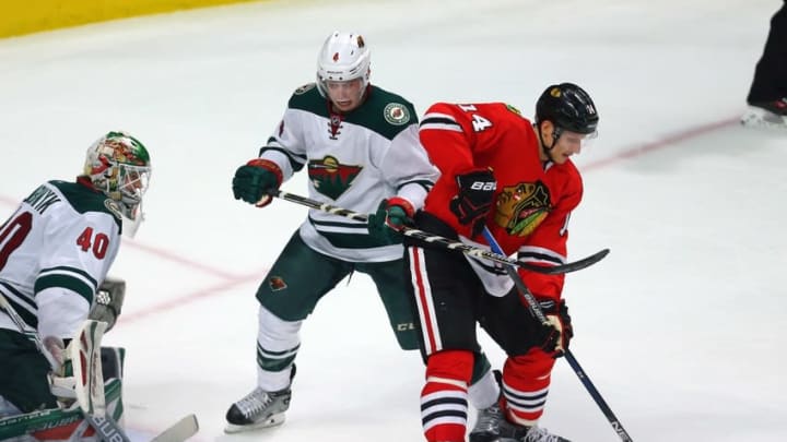 Mar 20, 2016; Chicago, IL, USA; Chicago Blackhawks right wing Richard Panik (14) attempts to tip the puck in front of Minnesota Wild goalie Devan Dubnyk (40) and defenseman Mike Reilly (4) during the third period at the United Center. Minnesota won 3-2 in a shoot out. Mandatory Credit: Dennis Wierzbicki-USA TODAY Sports