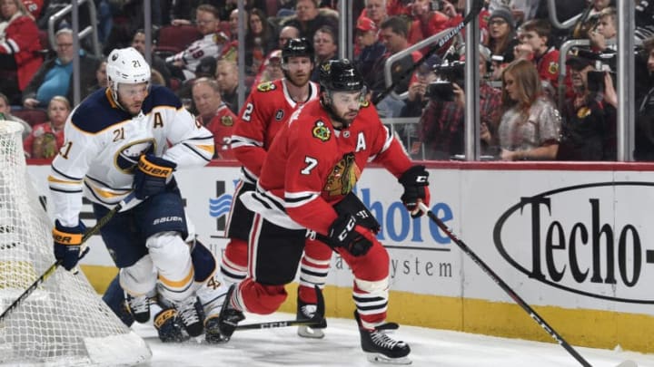 CHICAGO, IL - MARCH 07: Brent Seabrook #7 of the Chicago Blackhawks grabs the puck ahead of Kyle Okposo #21 of the Buffalo Sabres in the second period at the United Center on March 7, 2019 in Chicago, Illinois. (Photo by Bill Smith/NHLI via Getty Images)