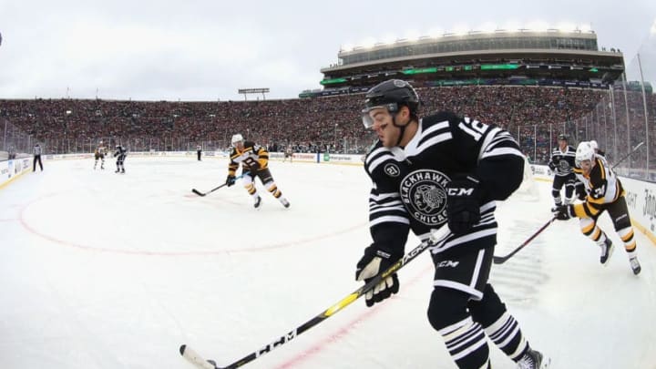 SOUTH BEND, IN - JANUARY 01: Alex DeBrincat #12 of the Chicago Blackhawks controls the puck during the first period of the 2019 Bridgestone NHL Winter Classic game against the Boston Bruins at Notre Dame Stadium on January 1, 2019 in South Bend, Indiana. (Photo by Dave Sandford/NHLI via Getty Images)