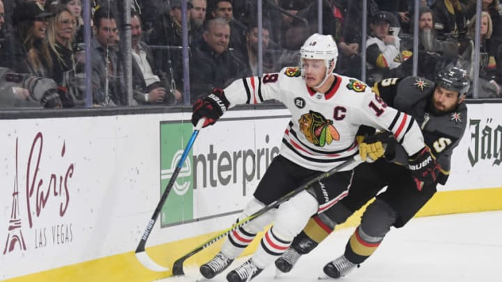 LAS VEGAS, NEVADA - DECEMBER 06: Jonathan Toews #19 of the Chicago Blackhawks and Deryk Engelland #5 of the Vegas Golden Knights chase after the puck in the third period of their game at T-Mobile Arena on December 6, 2018 in Las Vegas, Nevada. The Golden Knights defeated the Blackhawks 4-3. (Photo by Ethan Miller/Getty Images)