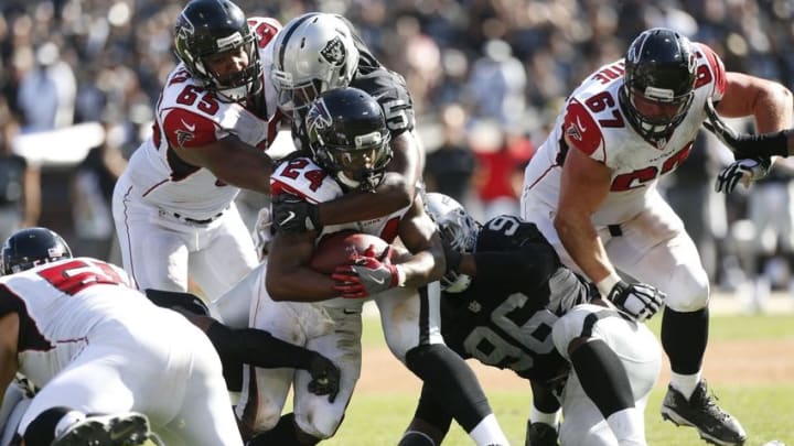 Sep 18, 2016; Oakland, CA, USA; Atlanta Falcons running back Devonta Freeman (24) is tackled by Oakland Raiders defensive end Jihad Ward (95) in the fourth quarter at Oakland-Alameda County Coliseum. The Falcons defeated the Raiders 35-28. Mandatory Credit: Cary Edmondson-USA TODAY Sports