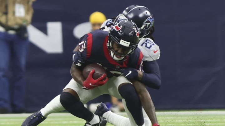 Jan 9, 2022; Houston, Texas, USA; Houston Texans wide receiver Brandin Cooks (13) is tackled by Tennessee Titans cornerback Janoris Jenkins (20) in the second quarter at NRG Stadium. Mandatory Credit: Thomas Shea-USA TODAY Sports