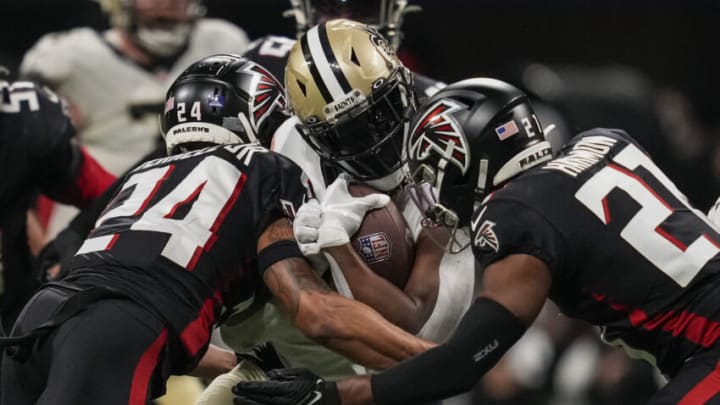 Jan 9, 2022; Atlanta, Georgia, USA; New Orleans Saints running back Alvin Kamara (41) is tackled by Atlanta Falcons cornerback A.J. Terrell (24) and safety Richie Grant (27) during the second half at Mercedes-Benz Stadium. Mandatory Credit: Dale Zanine-USA TODAY Sports