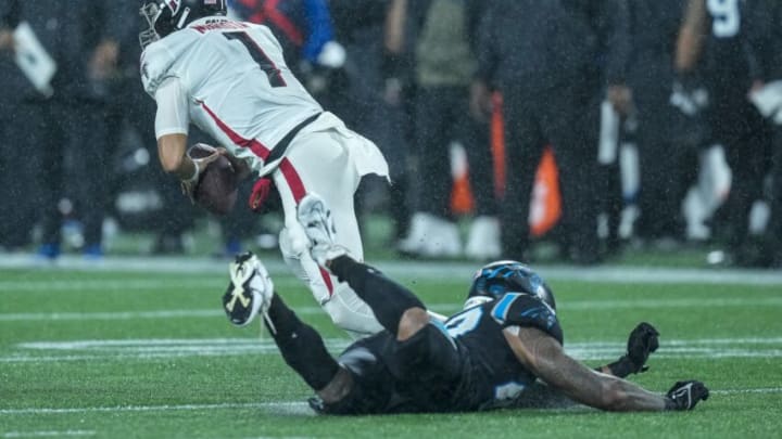 Nov 10, 2022; Charlotte, North Carolina, USA; Atlanta Falcons quarterback Marcus Mariota (1) is tripped up by Carolina Panthers linebacker Frankie Luvu (49) during the second half at Bank of America Stadium. Mandatory Credit: Jim Dedmon-USA TODAY Sports