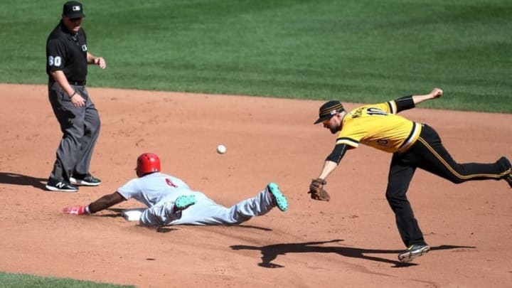 Sep 11, 2016; Pittsburgh, PA, USA; Cincinnati Reds second baseman Brandon Phillips (4) slides into second base with a double as Pittsburgh Pirates shortstop Jordy Mercer (10) reaches for a wide throw during the fifth inning at PNC Park. Mandatory Credit: Charles LeClaire-USA TODAY Sports