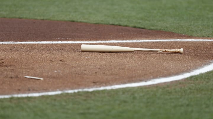 A broken bat lays on the ground. Could the Reds select a power hitter?