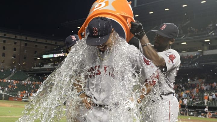 Aug 16, 2016; Baltimore, MD, USA; Boston Red Sox center fielder Jackie Bradley Jr. (left) and left fielder Andrew Benintendi (40) dunk water on right fielder Mookie Betts (50) during a post game interview after defeating Baltimore Orioles 5-3 at Oriole Park at Camden Yards. Mandatory Credit: Tommy Gilligan-USA TODAY Sports