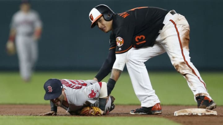 BALTIMORE, MD - APRIL 21: Dustin Pedroia #15 of the Boston Red Sox lays injured on the field after colliding at second base with Manny Machado #13 of the Baltimore Orioles in the eighth inning at Oriole Park at Camden Yards on April 21, 2017 in Baltimore, Maryland. (Photo by Matt Hazlett/Getty Images)