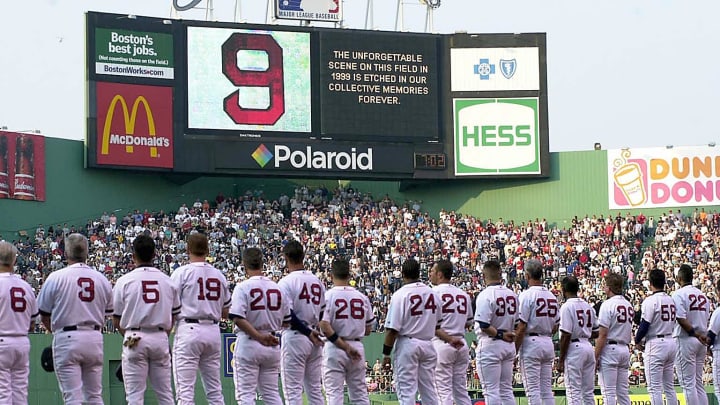 BOSTON, UNITED STATES: Members of the Boston Red Sox pay tribute to Ted Williams beneath a large number 9, Williams’ uniform number, during a ceremony prior to their game with the Detroit Tigers 05 July 2002 at Fenway Park in Boston, Massachusetts. Red Sox Hall of Famer legend Williams died 05 July 2002 at the age of 83. AFP PHOTO/JESSICA RINALDI (Photo credit should read JESSICA RINALDI/AFP via Getty Images)