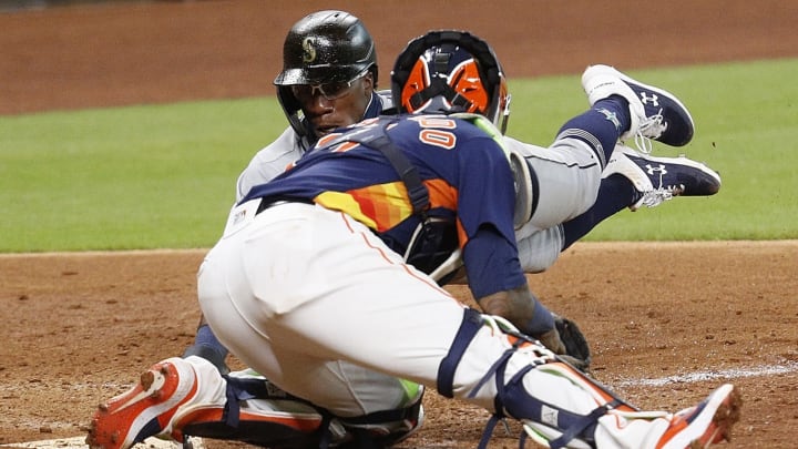 HOUSTON, TEXAS – JULY 26: Shed Long Jr. #4 of the Seattle Mariners scores on a single by Kyle Lewis #1 in the eighth inning as Martin Maldonado #15 of the Houston Astros is late with the tag at Minute Maid Park on July 26, 2020 in Houston, Texas. (Photo by Bob Levey/Getty Images)