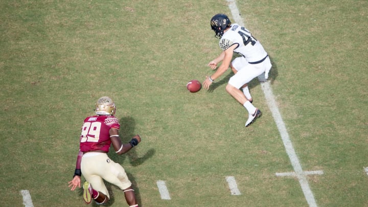 TALLAHASSEE, FL – OCTOBER 15: Punter Dom Maggio #48 of the Wake Forest Demon Deacons fumbles the ball in front of defensive end Brian Burns #99 of the Florida State Seminoles at Doak Campbell Stadium on October 15, 2016 in Tallahassee, Florida. (Photo by Michael Chang/Getty Images)