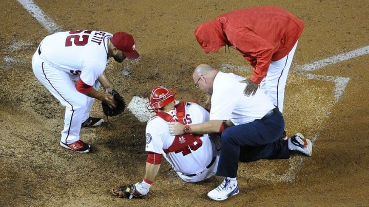Sep 26, 2016; Washington, DC, USA; Washington Nationals catcher Wilson Ramos (40) is looked at by the team trainer Paul Lessard and relief pitcher Yusmeiro Petit (52) and manager Dusty Baker (12) after suffering an apparent right knee injury during the sixth inning against the Arizona Diamondbacks at Nationals Park. Mandatory Credit: Brad Mills-USA TODAY Sports