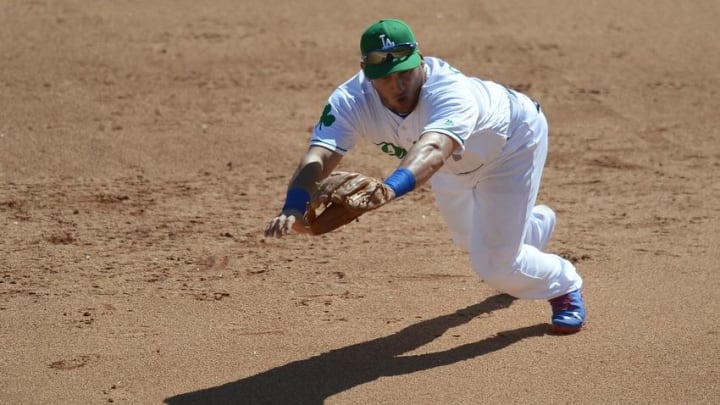 Mar 17, 2016; Phoenix, AZ, USA; Los Angeles Dodgers third baseman Alex Guerrero (7) dives for a ground ball during the fifth inning against the Kansas City Royals at Camelback Ranch. Mandatory Credit: Joe Camporeale-USA TODAY Sports