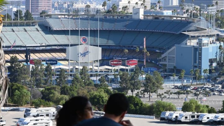 A couple looks out over the Los Angeles city skyline and Dodgers Stadium ahead of the opening day game between the Los Angeles Dodgers and the San Francisco Giants, July 23, 2020 in Los Angeles, California. - The game will be played without fans in the stadium due to the COVID-19 pandemic. (Photo by Robyn Beck / AFP) (Photo by ROBYN BECK/AFP via Getty Images)