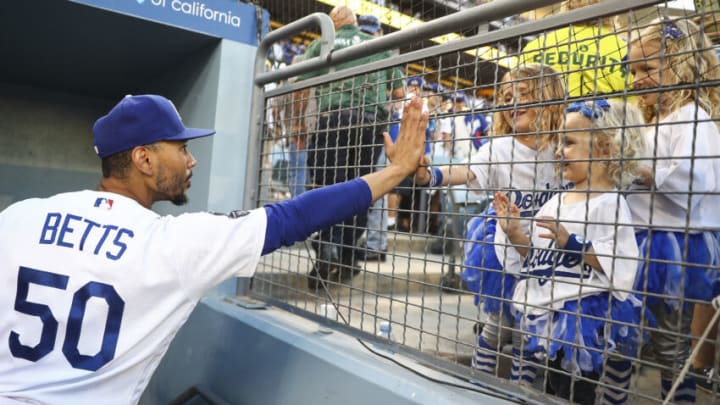 LOS ANGELES, CALIFORNIA - JUNE 26: Mookie Betts #50 of the Los Angeles Dodgers high fives with fans after the game against the Chicago Cubs at Dodger Stadium on June 26, 2021 in Los Angeles, California. The Dodgers defeated the Cubs 3-2. (Photo by Meg Oliphant/Getty Images)