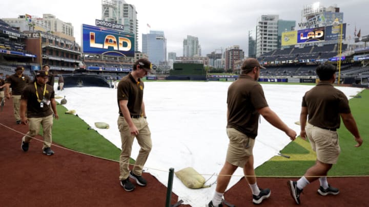 SAN DIEGO, CALIFORNIA - OCTOBER 15: Grounds crew cover the field with tarp as rain falls before the game between the Los Angeles Dodgers and the San Diego Padres in the Division Series at PETCO Park on October 15, 2022 in San Diego, California. (Photo by Harry How/Getty Images)