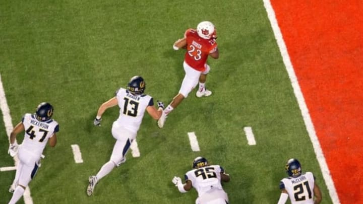 Oct 10, 2015; Salt Lake City, UT, USA; Utah Utes running back Devontae Booker (23) scores a touchdown ahead of California Golden Bears defensive end Kyle Kragen (13) and linebacker Hardy Nickerson (47) and defensive end DeVante Wilson (95) and safety Stefan McClure (21) during the first half at Rice-Eccles Stadium. Mandatory Credit: Russ Isabella-USA TODAY Sports