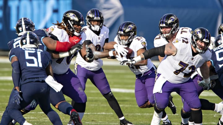 NASHVILLE, TENNESSEE – JANUARY 10: Quarterback Lamar Jackson #8 hands off the ball to J.K. Dobbins #27 of the Baltimore Ravens during their AFC Wild Card Playoff game against the Tennessee Titans at Nissan Stadium on January 10, 2021, in Nashville, Tennessee. The Ravens defeated the Titans 20-13. (Photo by Wesley Hitt/Getty Images)
