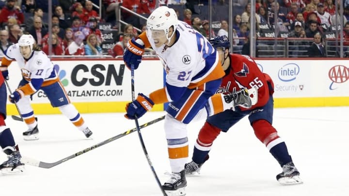 Apr 5, 2016; Washington, DC, USA; New York Islanders center Anders Lee (27) shoots the puck as Washington Capitals left wing Andre Burakovsky (65) chases in the third period at Verizon Center. The Islanders won 4-3 in overtime. Mandatory Credit: Geoff Burke-USA TODAY Sports