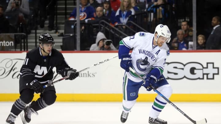 Nov 7, 2016; Brooklyn, NY, USA; Vancouver Canucks left wing Daniel Sedin (22) steals the puck from New York Islanders center Shane Prince (11) and scores during the first period at Barclays Center. Mandatory Credit: Brad Penner-USA TODAY Sports
