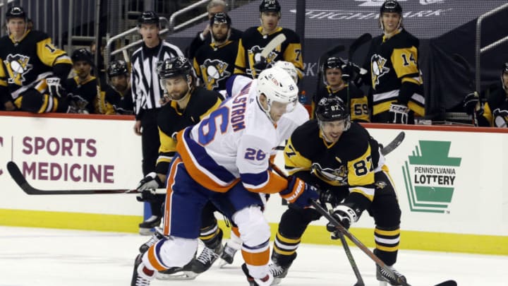 Feb 20, 2021; Pittsburgh, Pennsylvania, USA; New York Islanders right wing Oliver Wahlstrom (26) moves the puck past Pittsburgh Penguins center Sidney Crosby (87) during the second period at PPG Paints Arena. Mandatory Credit: Charles LeClaire-USA TODAY Sports