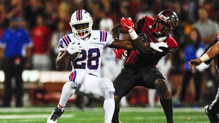 Sep 10, 2015; Bowling Green, KY, USA; Louisiana Tech Bulldogs running back Kenneth Dixon (28) carries the ball away from Western Kentucky Hilltoppers defensive back Martavius Mims (27) during the first half at Houchens Industries-L.T. Smith Stadium. Mandatory Credit: Joshua Lindsey-USA TODAY Sports