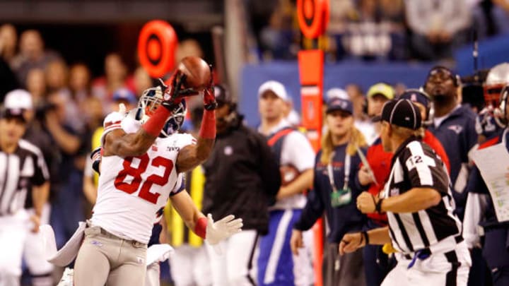 INDIANAPOLIS, IN – FEBRUARY 05: Mario Manningham #82 of the New York Giants makes a catch on the sidelines against Patrick Chung #25 (L) and Sterling Moore #29 (obscured) of the New England Patriots for a gain of 39 yards in the fourth quarter during Super Bowl XLVI at Lucas Oil Stadium on February 5, 2012 in Indianapolis, Indiana. (Photo by Rob Carr/Getty Images)