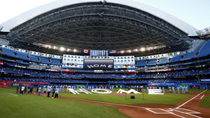 TORONTO, ON - JULY 30: The Toronto Blue Jays line up behind a 'Home' sign to commemorate their first home game in Toronto this season prior to a MLB game against the Kansas City Royals at Rogers Centre on July 30, 2021 in Toronto, Canada. (Photo by Vaughn Ridley/Getty Images)