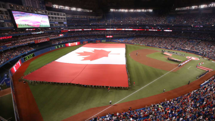 TORONTO, ON - JULY 1: A large Canadian flag is held by members of the military during the singing of the Canadian anthem on Canada Day before the start of the Toronto Blue Jays MLB game against the Detroit Tigers at Rogers Centre on July 1, 2018 in Toronto, Canada. (Photo by Tom Szczerbowski/Getty Images)