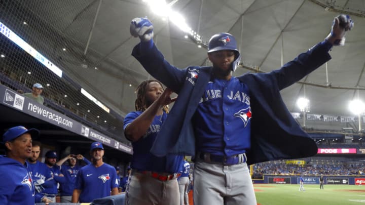 Sep 20, 2021; St. Petersburg, Florida, USA; Toronto Blue Jays left fielder Lourdes Gurriel Jr. (13) is congratulated by first baseman Vladimir Guerrero Jr. (27) as he puts on a jacket as he hits a home run during the fifth inning against the Tampa Bay Rays at Tropicana Field. Mandatory Credit: Kim Klement-USA TODAY Sports