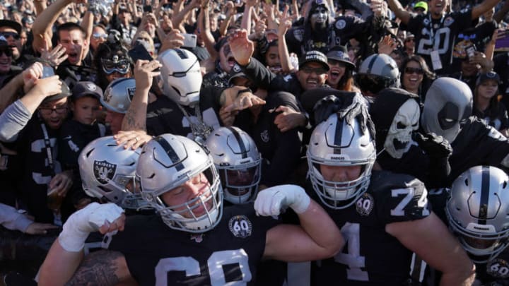 OAKLAND, CALIFORNIA - NOVEMBER 03: Josh Jacobs #28, Andre James #68 and Kolton Miller #74 of the Oakland Raiders celebrates with fans in the "The Black Hole" after Jacobs scored on a two yard touchdown run against the Detroit Lions during the second quarter of an NFL football game at RingCentral Coliseum on November 03, 2019 in Oakland, California. (Photo by Thearon W. Henderson/Getty Images)