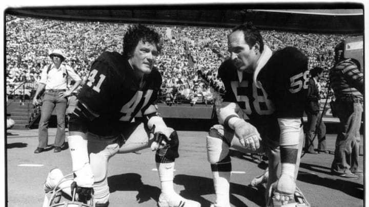 SAN FRANCISCO - AUGUST 20: Linebackers Phil Villapiano #41 and Monte Johnson #58 of the Oakland Raiders kneel on the sideline during a preseason game against the San Francisco 49ers at Candlestick Park on Aguust 20, 1978 in San Francisco, California. (Photo by Michael Zagaris/Getty Images)