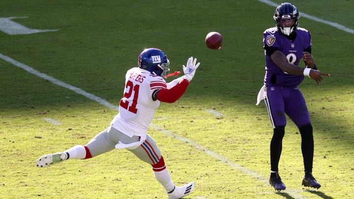 BALTIMORE, MARYLAND – DECEMBER 27: Quarterback Lamar Jackson #8 of the Baltimore Ravens passes while being pressured by strong safety Jabrill Peppers #21 of the New York Giants at M&T Bank Stadium on December 27, 2020, in Baltimore, Maryland. (Photo by Rob Carr/Getty Images)