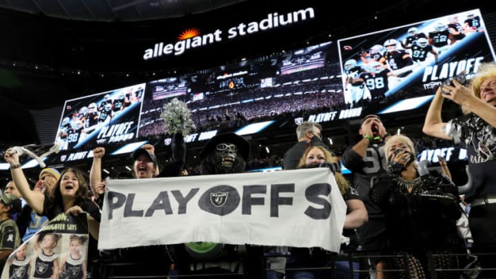 LAS VEGAS, NEVADA - JANUARY 09: Las Vegas Raiders fans Marilyn Acasio (center L) and her husband Mark "Gorilla Rilla" Acasio of California hold up a banner with the word "playoffs" after the Raiders' 35-32 overtime win over the the Los Angeles Chargers at Allegiant Stadium on January 9, 2022 in Las Vegas, Nevada. (Photo by Ethan Miller/Getty Images)