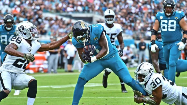 Jacksonville Jaguars running back Travis Etienne Jr. (1) is tackled on the one-yard line by Las Vegas Raiders safety Duron Harmon (30) and cornerback Rock Ya-Sin (26) during second-quarter action. This set up Etienne’s touchdown dive on the next play. The Jacksonville Jaguars hosted the Las Vegas Raiders at TIAA Bank Field in Jacksonville, FL Sunday, November 6, 2022. The Jaguars trailed 20 to 10 at the end of the first half. [Bob Self/Florida Times-Union]Jki 110622 Bs Jaguars Vs R 39