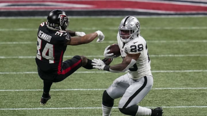 Nov 29, 2020; Atlanta, Georgia, USA; Las Vegas Raiders running back Josh Jacobs (28) avoids a tackle by Atlanta Falcons cornerback Darqueze Dennard (34) during the first quarter at Mercedes-Benz Stadium. Mandatory Credit: Dale Zanine-USA TODAY Sports