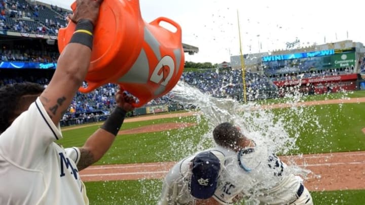 May 15, 2016; Kansas City, MO, USA; Kansas City Royals designated hitter Kendrys Morales (25) and catching coach Pedro Grifol (28) his interpreter are doused by catcher Salvador Perez (13) after the win over the Atlanta Braves at Kauffman Stadium. The Royals won 4-2. Mandatory Credit: Denny Medley-USA TODAY Sports