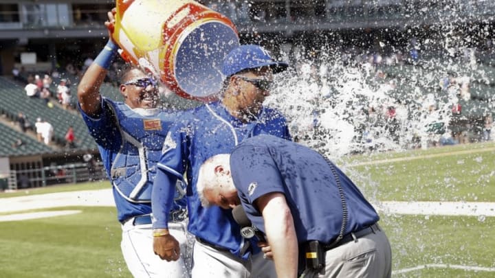 Jun 11, 2016; Chicago, IL, USA; Kansas City Royals catcher Salvador Perez (left) dumps water on teammate third baseman Cheslor Cuthbert (middle) as Joel Goldberg interviews him after a 4-1 win against the Chicago White Sox at U.S. Cellular Field. Mandatory Credit: Kamil Krzaczynski-USA TODAY Sports