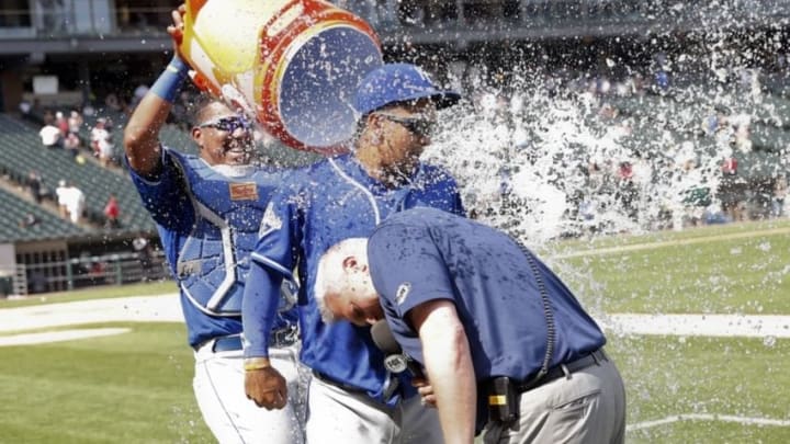 Jun 11, 2016; Chicago, IL, USA; Kansas City Royals catcher Salvador Perez (left) dumps water on teammate third baseman Cheslor Cuthbert (middle) as Joel Goldberg interviews him after a 4-1 win against the Chicago White Sox at U.S. Cellular Field. Mandatory Credit: Kamil Krzaczynski-USA TODAY Sports