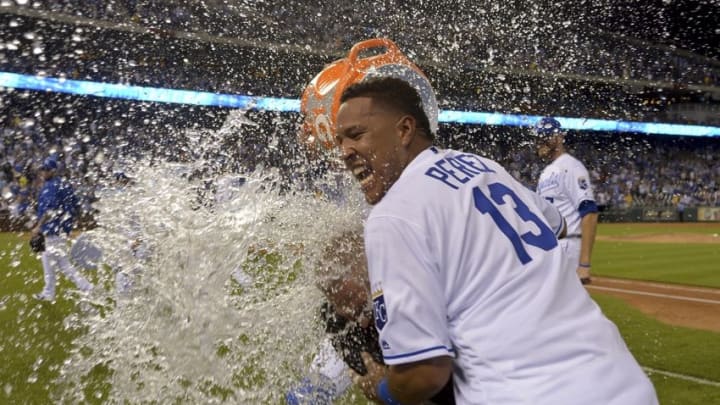 Jun 14, 2016; Kansas City, MO, USA; Kansas City Royals catcher Salvador Perez (13) and Fox announcer Joel Goldberg are doused by catcher Drew Butera (9) after the win over the Cleveland Indians at Kauffman Stadium. The Royals won 3-2. Mandatory Credit: Denny Medley-USA TODAY Sports