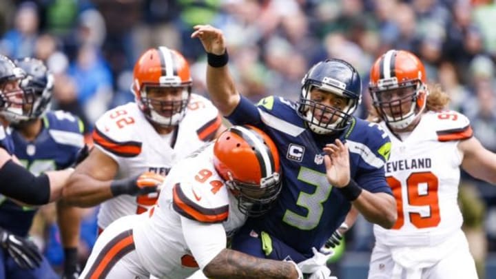 Dec 20, 2015; Seattle, WA, USA; Seattle Seahawks quarterback Russell Wilson (3) is hit by Cleveland Browns defensive end Randy Starks (94) after making a pass during the first quarter at CenturyLink Field. Seattle defeated Cleveland, 30-13. Mandatory Credit: Joe Nicholson-USA TODAY Sports