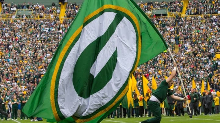 Oct 19, 2014; Green Bay, WI, USA; A Green Bay Packers cheerleader carries a Packers flag prior to the game against the Carolina Panthers at Lambeau Field. Green Bay won 38-17. Jeff Hanisch-USA TODAY Sports