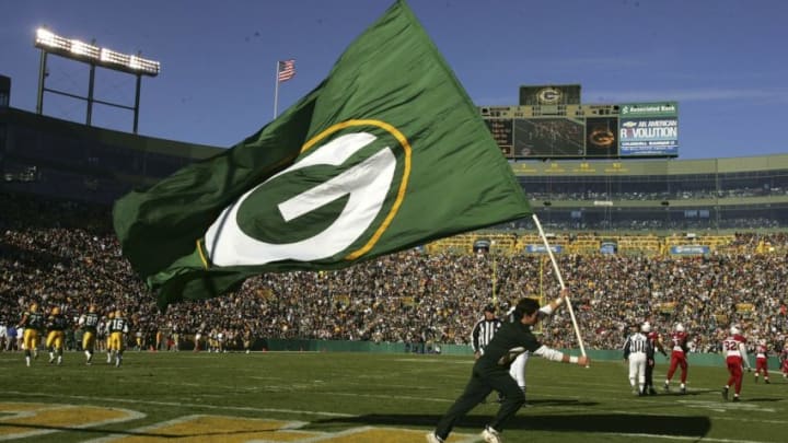 GREEN BAY, WI - OCTOBER 29: A cheedleader carries a Packer flag across the end zone after the Green Bay Packers scored a touchdown against the Arizona Cardinals on October 29, 2006 at Lambeau Field in Green Bay, Wisconsin. The Packers won 31-14. (Photo by Stephen Dunn/Getty Images)